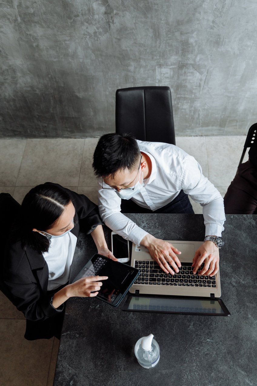 A Top View of Co-Workers in an Office Using Their Gadgets
